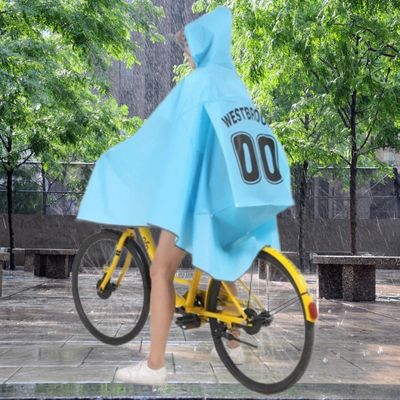 FEMME AVEC CAPE DE PLUIE VELO PARTENAIRE SOUS AVERSE