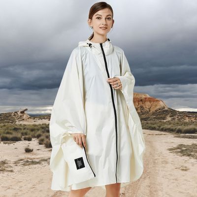 Femme avec cape de pluie confortable dunes nuages sombres