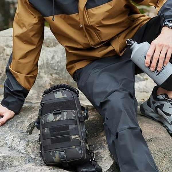 Sacoche bandoulière tactique TrailSling camouflage posée sur un rocher