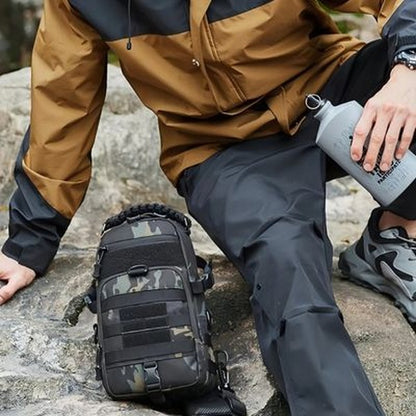 Sacoche bandoulière tactique TrailSling camouflage posée sur un rocher