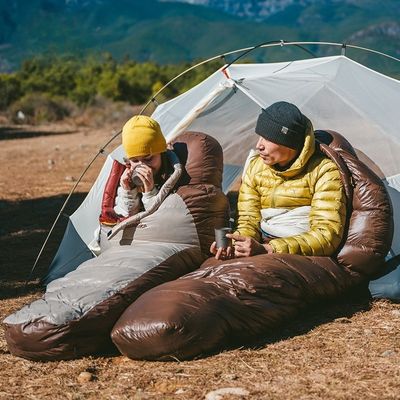 Couple chacun sac de couchage grand froid café devant tente
