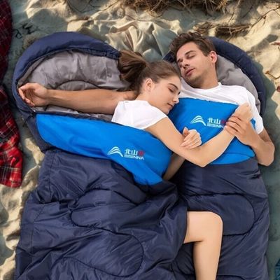 Couple endormi dans sacs de couchage connectés sur plage