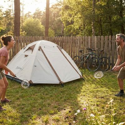 Couple joue raquettes côté tente dome installée près palissade