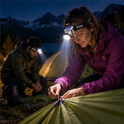 Couple monte tente bivouac soir avec puissante lampe frontale