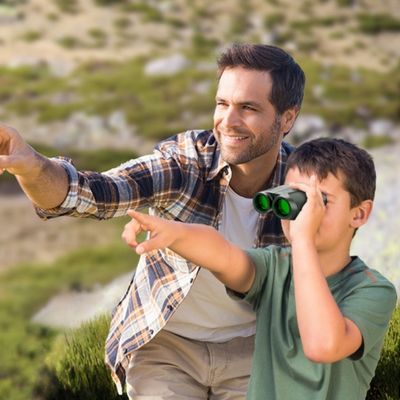 Enfant avec jumelles compactes montre animal son père
