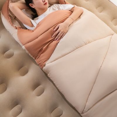 Femme allongée sur matelas dans sac de couchage douillet