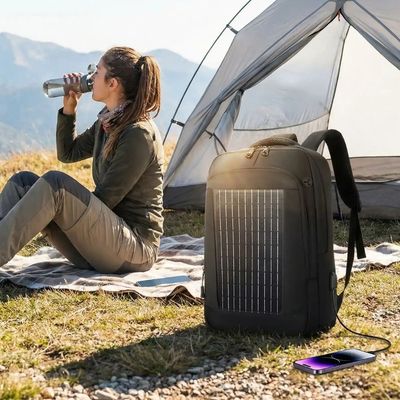 Femme assise devant tente sac chargeur solaire recharge portable