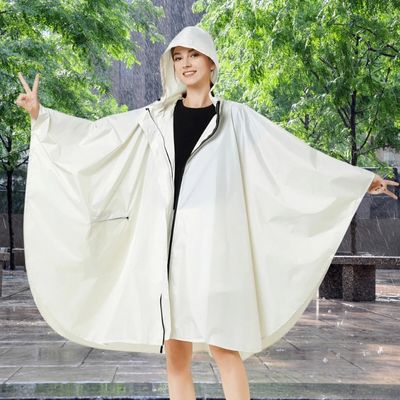 Femme avec cape de pluie élégante sur place averse