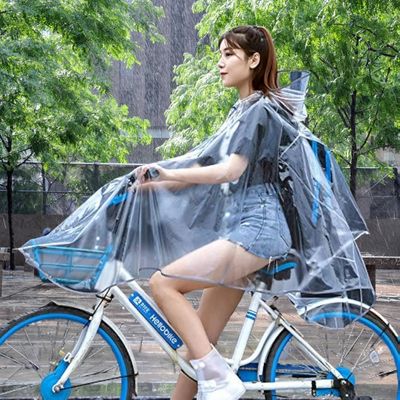 Femme avec cape de pluie vélo sur place