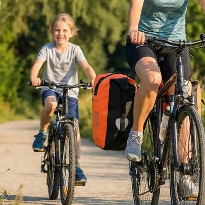Femme avec enfants sur voie verte sacoches vélo fixées