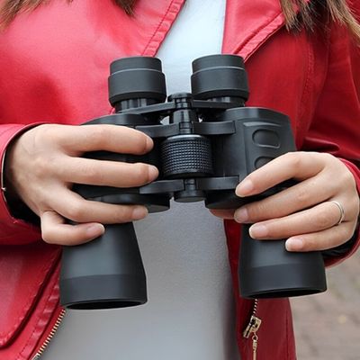 Femme avec jumelle pour randonnée main prête observation