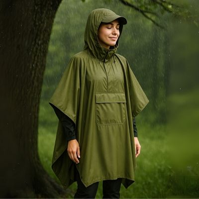 Femme avec poncho pluie abritée sous arbre