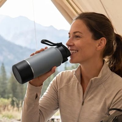 Femme boit gourde isotherme 2l sous tente
