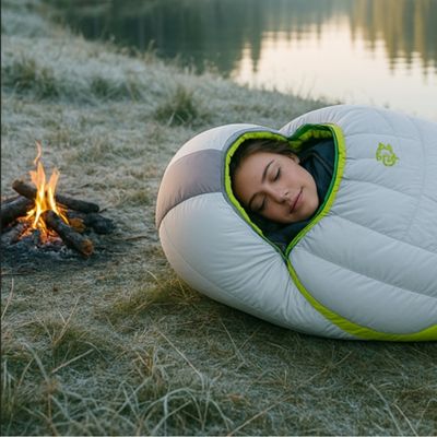 Femme dans sac de couchage grand froid près feu