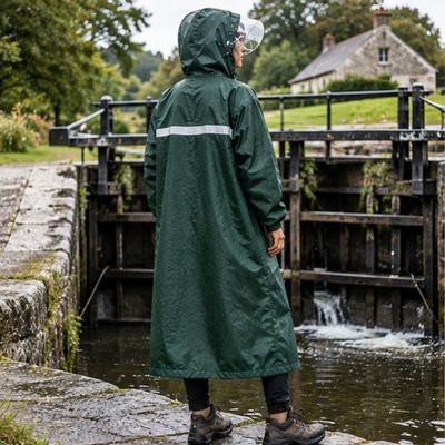 Femme debout devant écluse cape de pluie randonnée