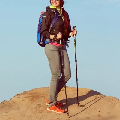 Femme debout sur rocher batons de trail