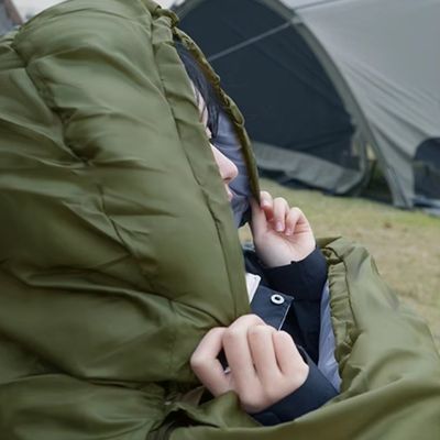 Femme emmitouflée dans sac de couchage au loin