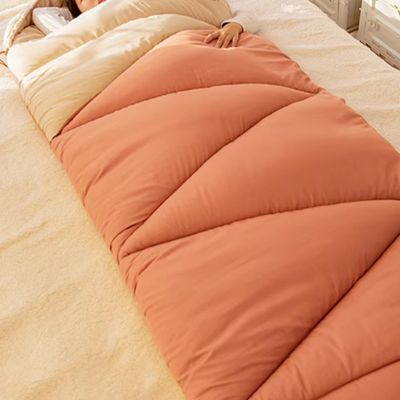 Femme endormie sur lit dans sac de couchage douillet