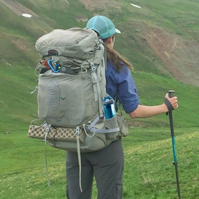 Femme gourde filtrante randonnée dans poche côté sac à dos