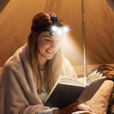Femme lit après randonnée lampe frontale dans tente