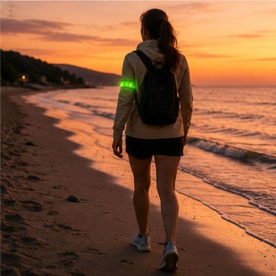 Femme marche matin tôt avec brassard lumineux sur plage