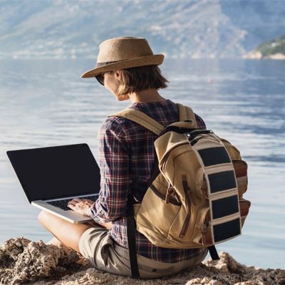 Femme mer assise rocher panneau solaire souple attaché sac