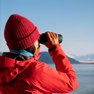 Femme observe avec jumelles pour randonnée grands espaces