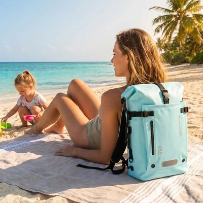 Femme plage avec sac à dos étanche regarde fille jouer