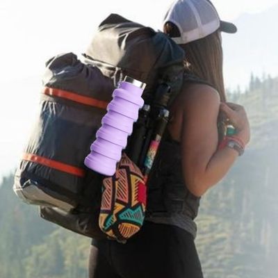 Femme randonne avec gourde pour sport fixée sac