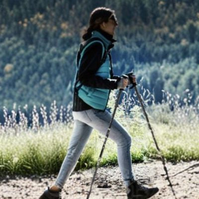Femme randonne chemin escarpé avec batons de randonnée