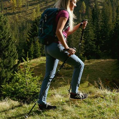 Femme randonne plateau alpin avec batons de randonnée