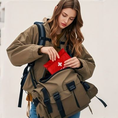 Femme range randonnée trousse de secours dans sac bandoulière
