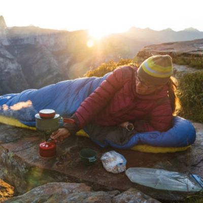 Femme sac de couchage prépare déjeuner