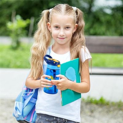 Fillette gourde en plastique en main et sac à dos