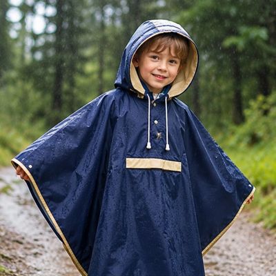 Garçon couvert poncho pluie enfant sous pluie