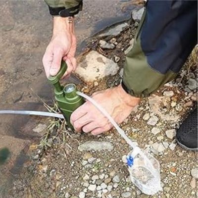 Homme actionne filtre à eau portable bord ruisseau