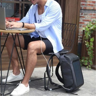 Homme assis jardin sac à dos voyage charge ordinateur