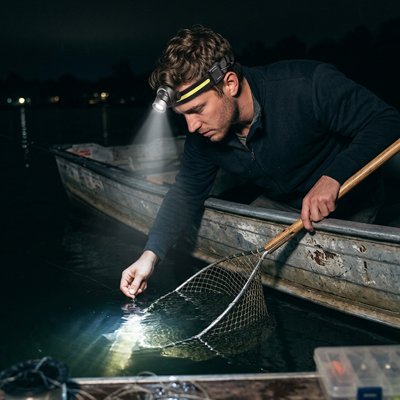 Homme attire poisson filet lampe frontale sur tête