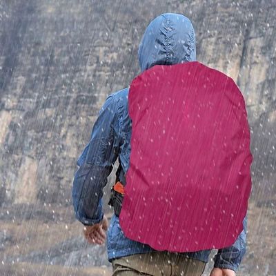 Homme avec housse de pluie sous averse