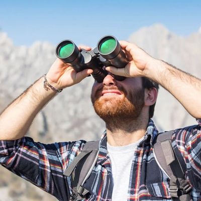 Homme avec jumelle pour randonnée observe clairement montagne