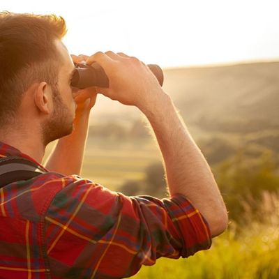 Homme avec jumelle pour randonnée robuste explore crêtes