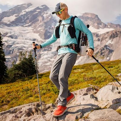 Homme batons marche nordique descend rochers