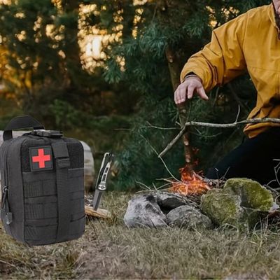 Homme bivouac trousse premier secours posée côté feu