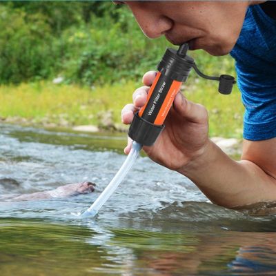 Homme boit avec filtre à eau prolongateur dans torrent