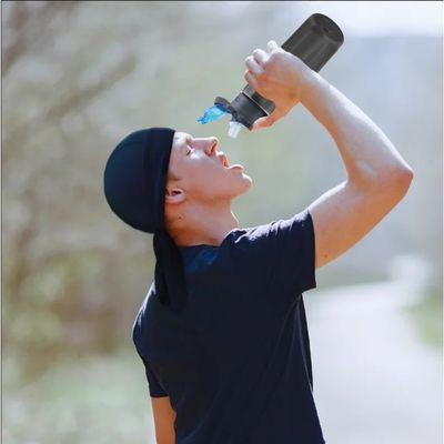 Homme boit avec sa gourde filtre eau