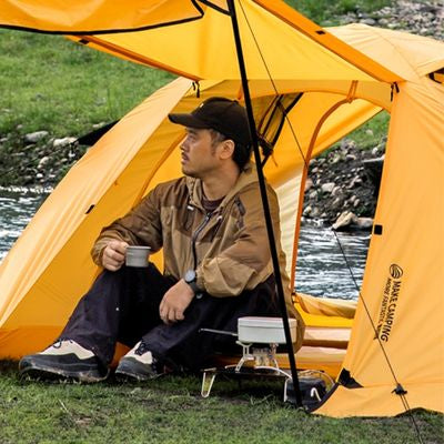 Homme boit café dans tente trekking 2 places