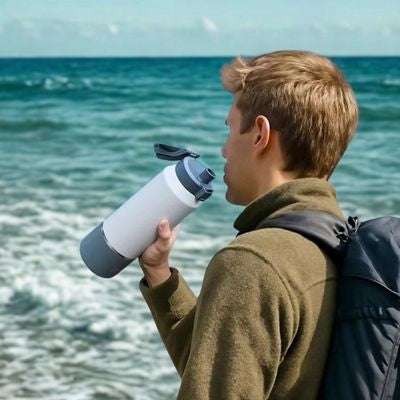 Homme boit gourde isotherme 2l bord mer