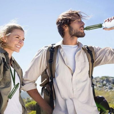 Homme boit paille pour filtrer l'eau montée directement bouteille