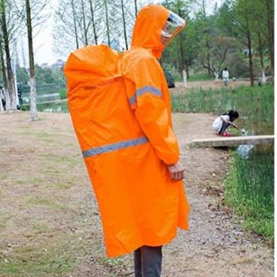 Homme bord étang cape de pluie couvrant sac à dos