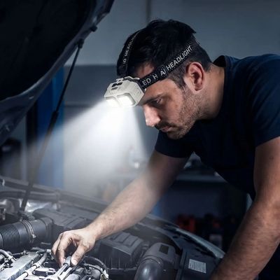 Homme bricole voiture avec meilleur lampe frontale pour travailler
